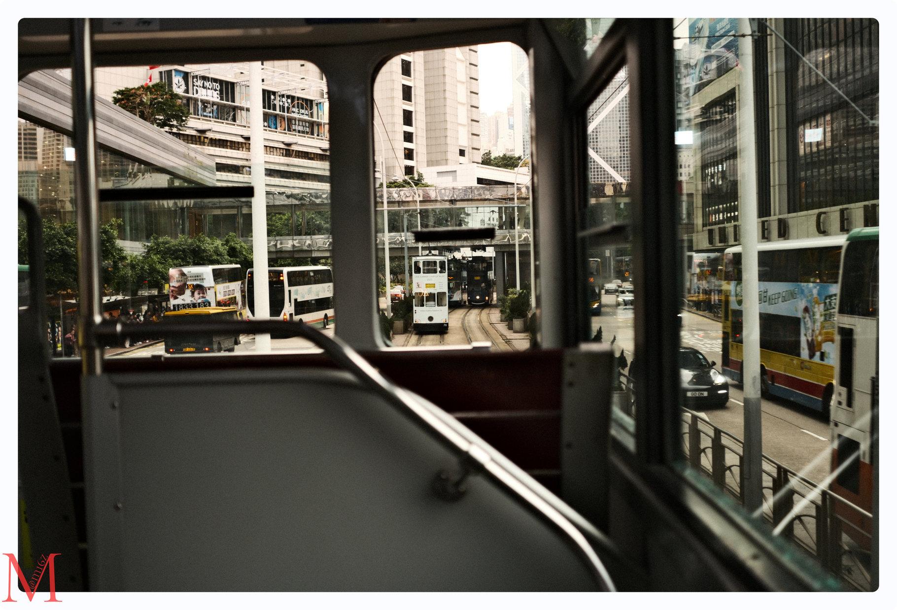 Sitzend in Hongkongs legendärer Ding Ding Tram, mit Blick aus dem Fenster auf eine weitere Ding Ding Tram.