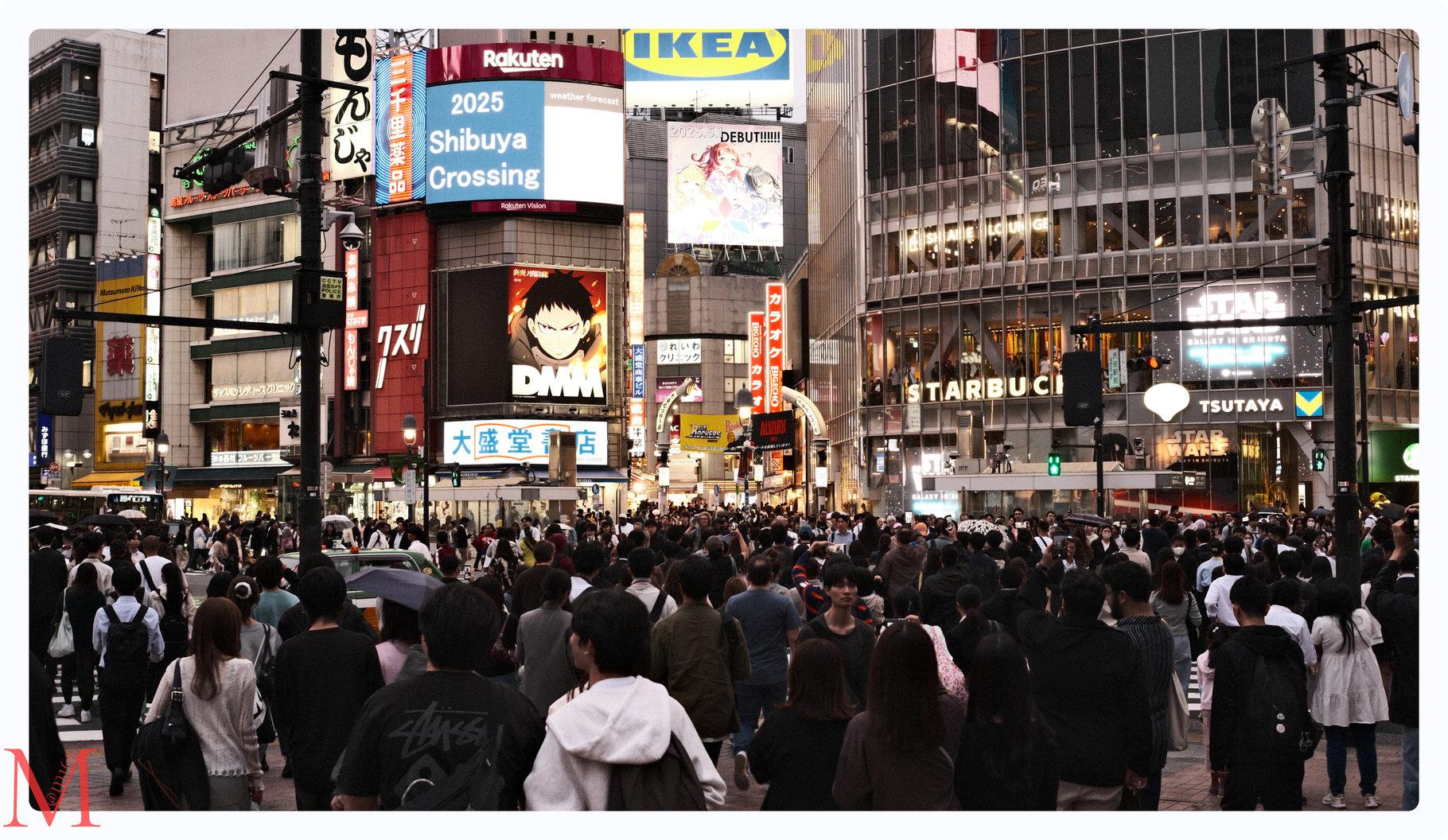 Menschenmassen überqueren die berühmte Shibuya-Kreuzung.